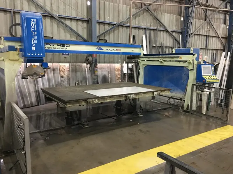 Máquina de corte de grande porte trabalhando uma chapa no galpão